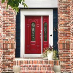 a red front door with two planters on the steps