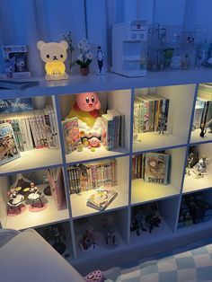 a book shelf filled with lots of books next to a stuffed animal on top of it