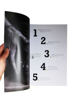 a hand is holding an open magazine with numbers on the front and back pages in it