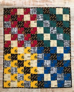 a quilt made with different colors and patterns on a wooden table top, showing the pattern