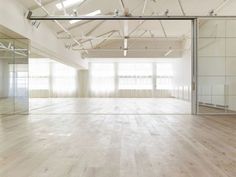 an empty room with wooden floors and mirrored walls