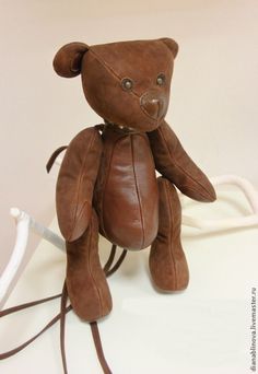 a brown teddy bear sitting on top of a white table