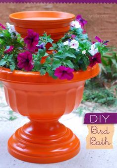 an orange flower pot with purple flowers in it