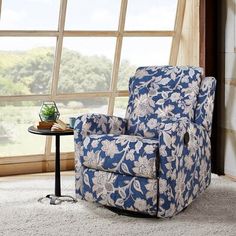 a blue and white chair sitting in front of a window next to a small table