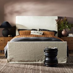 a bedroom with a bed, nightstands and two lamps on either side of the bed