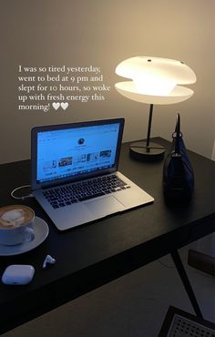 an open laptop computer sitting on top of a desk next to a cup of coffee