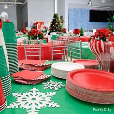 the table is set with red and green plates, silverware, and candy canes