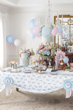 a table topped with lots of cake and balloons