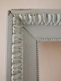 an old white frame with beading on the edges and bottom part of the frame