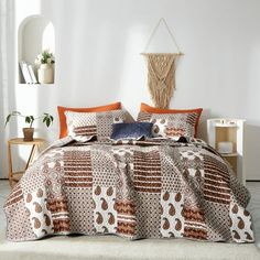 a bed with an orange and white comforter on it