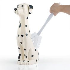 a dalmatian dog with a brush in it's mouth