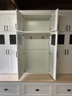 an empty closet with white cabinets and drawers