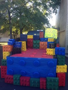 a playground made out of legos in front of a building with a sign on it