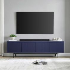 a flat screen tv mounted to the side of a blue cabinet in a living room