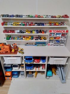 toy cars and trucks are on shelves in a playroom