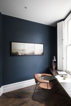 a chair sitting in front of a window on top of a hard wood floor next to a desk