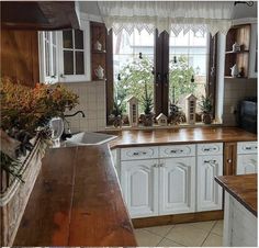 a kitchen with wooden counter tops and white cabinets