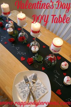 a valentine's day table setting with candles and napkins