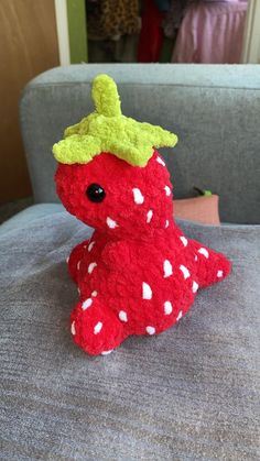 a red stuffed animal sitting on top of a couch