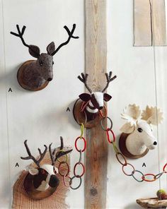 three deer head mounted to the side of a wooden wall with chains hanging from it's sides