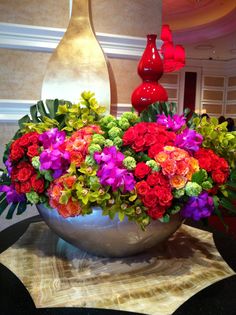 a large vase filled with colorful flowers on top of a table