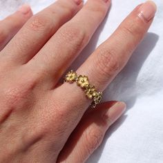 This ring features beautiful detailing and is shaped like a chain of daisies that wraps around the finger of the wearer.The ring comes as a size 7 and is moderately adjustable for the perfect fit.Made from stainless steel, this ring is tarnish resistant and safe to sweat, swim, and shower in. Adjustable Gold Metal Flower Ring, Adjustable Flower Shaped Metal Ring, Adjustable Metal Flower Ring, Dainty Adjustable Stackable Metal Rings, Adjustable Metal Flower Ring With Open Design, Adjustable Stainless Steel Stackable Rings, Adjustable Metal Flower Promise Ring, Dainty Adjustable Stackable Flower Ring, Adjustable Gold Flower Ring For Promise