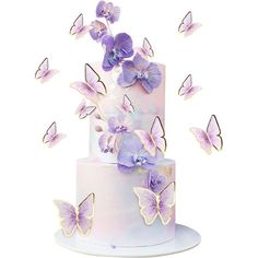 a three tiered cake with purple butterflies on top