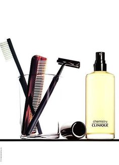 an assortment of hair and grooming products on a shelf next to a bottle of cologne