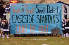 a group of cheerleaders holding up a sign that reads, trick r treat smell defect eastside spartans can't be beat