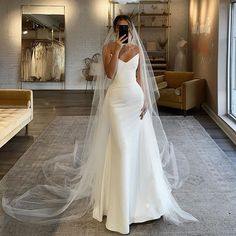 a woman in a white wedding dress is taking a selfie with her cell phone