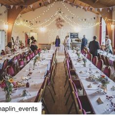 a banquet hall with long tables and hanging lights