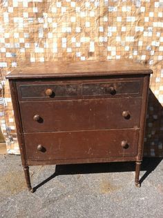 an old wooden dresser sitting in front of a wall