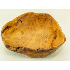 a wooden bowl sitting on top of a white table