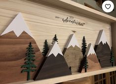 wooden mountains and trees are displayed on a shelf