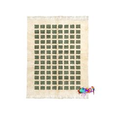 a white rug with green squares on it