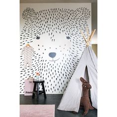 a child's room with a teepee tent and a bear wall mural on the wall