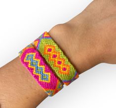 a close up of a person's hand wearing a bracelet with colorful designs on it