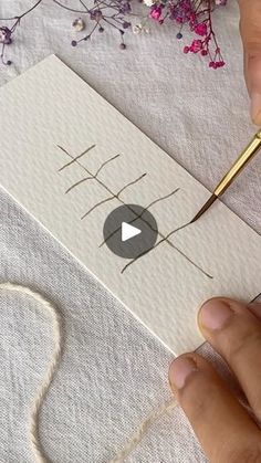 a person is using a needle to draw something