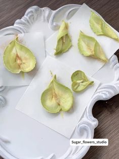 four pieces of avocado sitting on top of a white platter with napkins