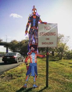 there is a sign that says no standing on shoulder and spider - man in front