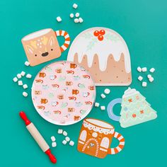 some paper plates and other items on a blue surface with candy, marshmallows