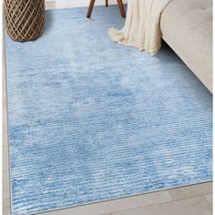 a blue area rug in a living room with a couch and table next to it