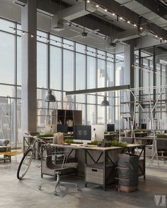 an office with large windows and lots of desks in the center, along with two bicycles