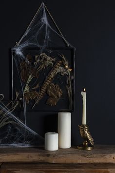 some candles are sitting on a table next to a spiderweave and other decorations