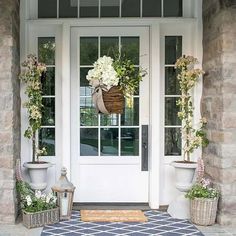 the front door is decorated with flowers and potted plants