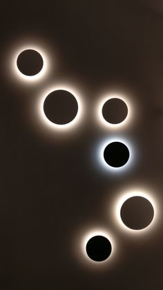 several circles are arranged in the middle of a wall with lights on each one side