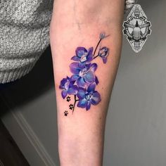 a purple flower tattoo on the left arm