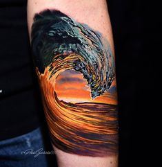 a man's arm with a colorful wave tattoo on it