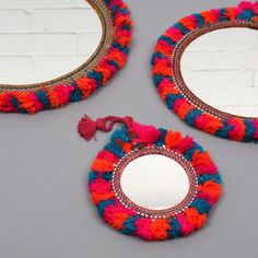 three round mirrors with tassels on them