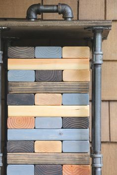 a close up of a clock made out of wooden planks and metal pipes on a wall